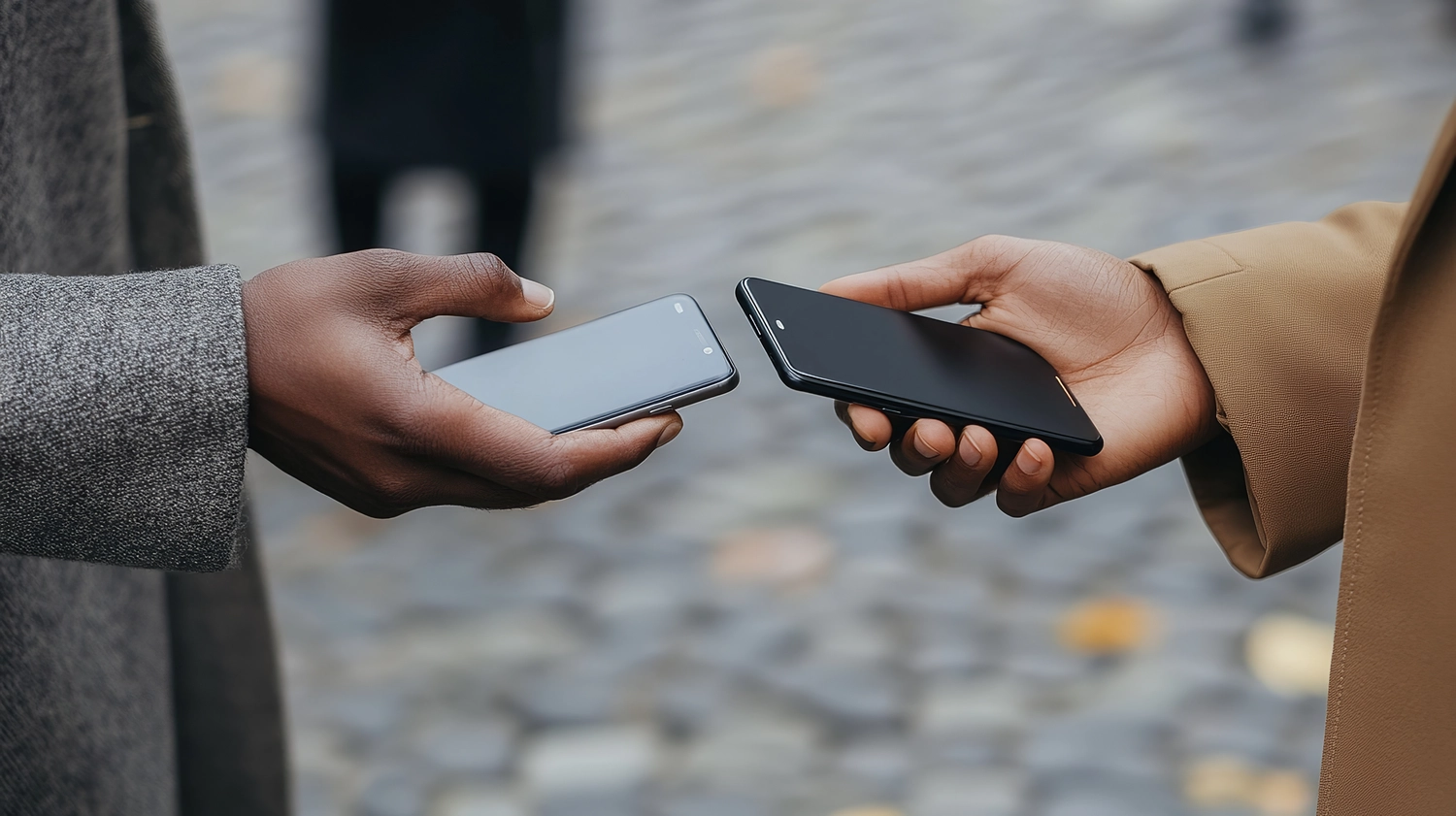 HZ Loop - Tauschapp mit KI - Zwei Personen tauschen Smartphones aus. Moderne Technologie, digitale Geräte, drahtlose Kommunikation, Mobiltelefone, Handheld-Geräte, urbanes Umfeld, lässiger Stil.